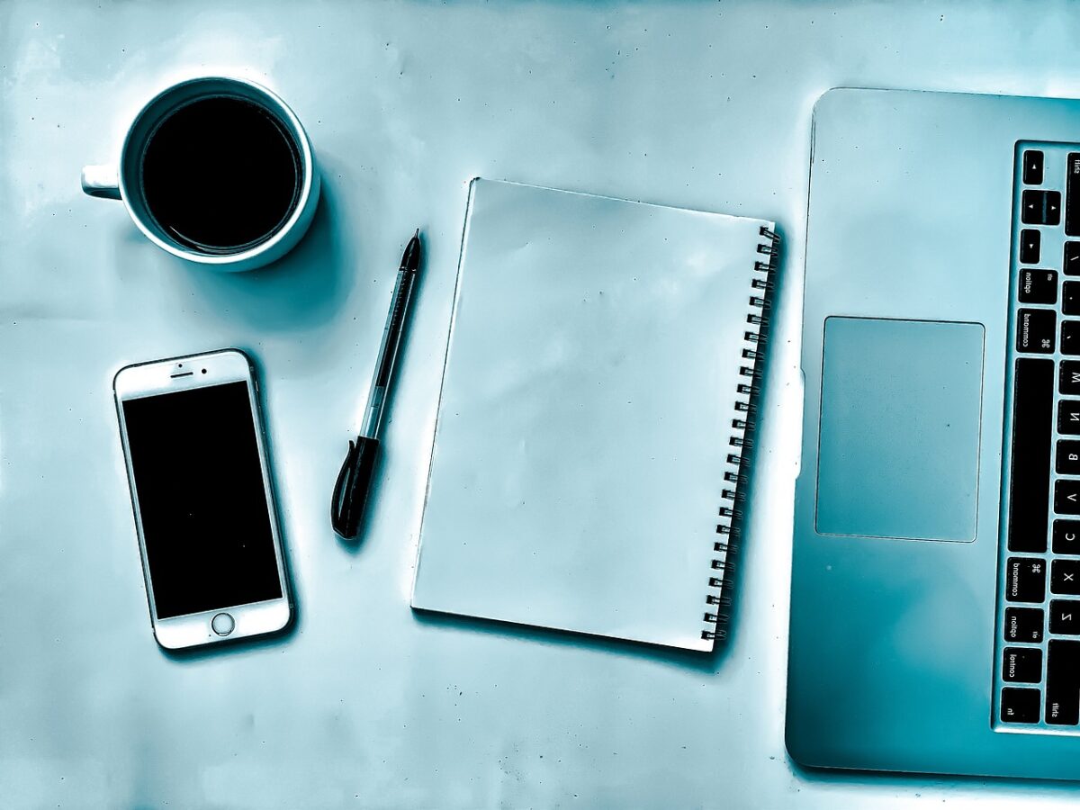 A clean workspace with a notebook, smartphone, and pen, representing the initial planning phase of a small business growth strategy roadmap.