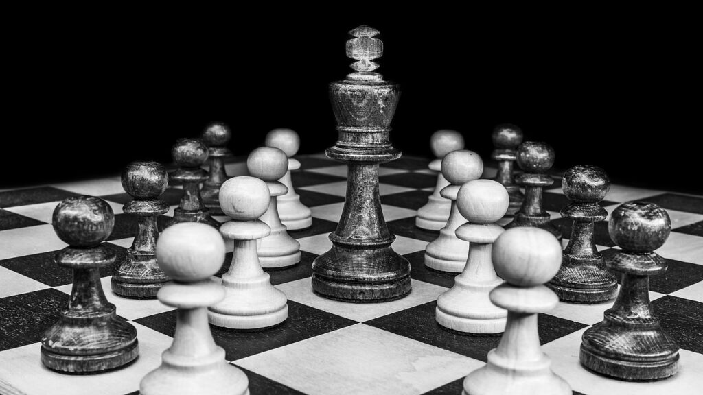 A close-up of a glass king chess piece standing centrally on a chessboard, representing strategic leadership and business foresight