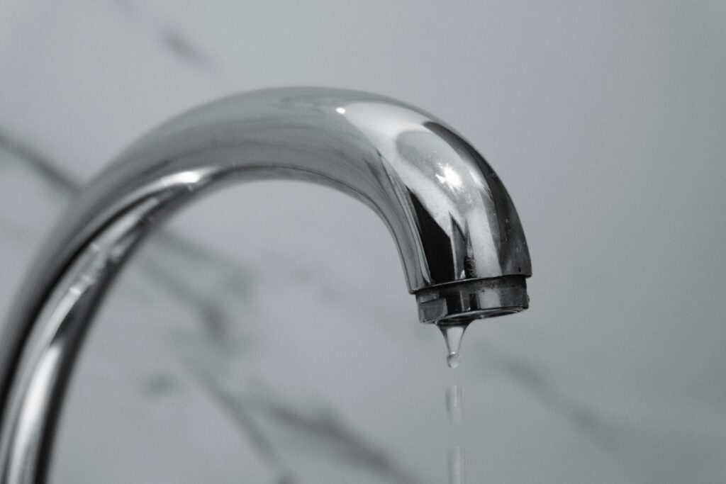 A dripping chrome faucet representing an ad spend leak caused by slow website loading speeds.