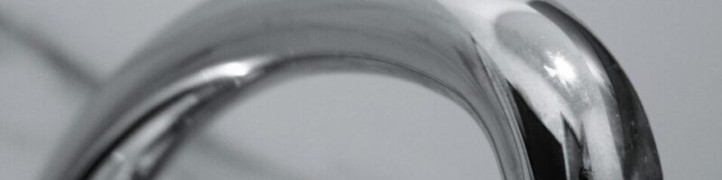 A dripping chrome faucet representing an ad spend leak caused by slow website loading speeds.