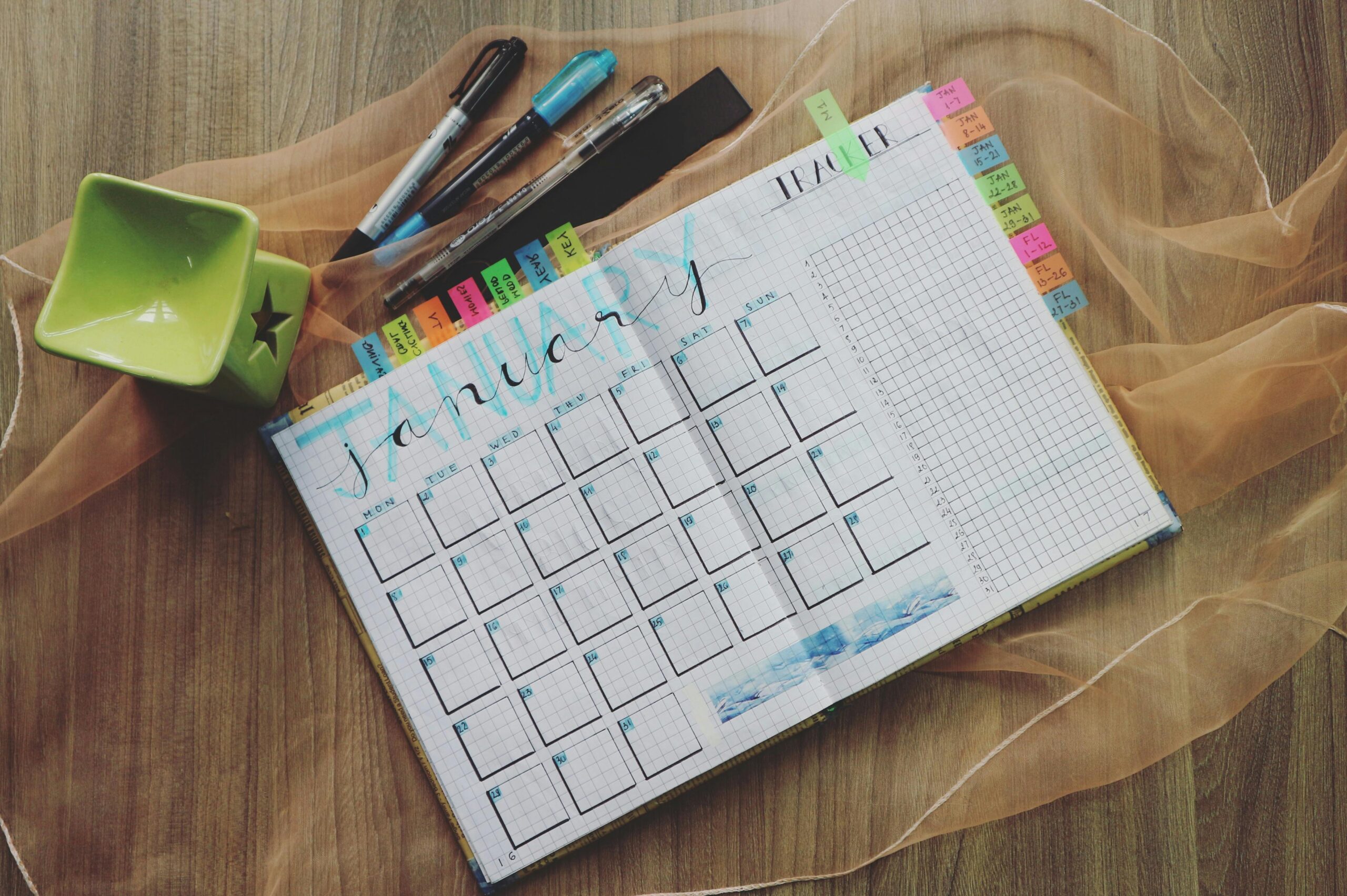 A top-down view of a clean monthly planner and notebook, used to build a strategic content calendar for a small business.